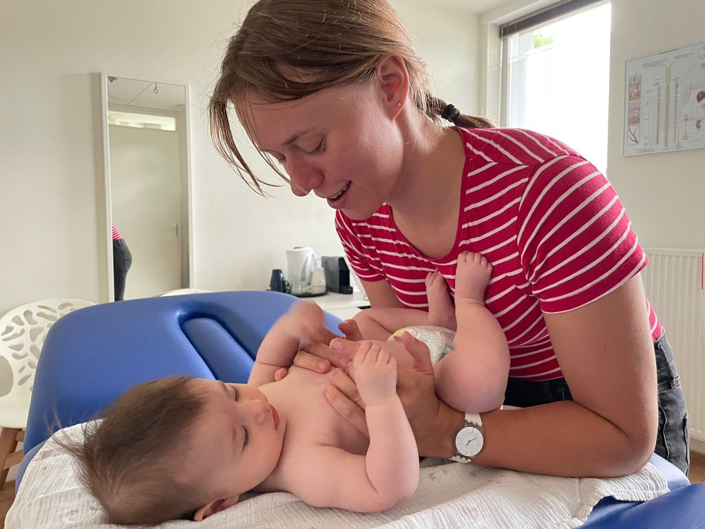 Isabelle behandelt een baby op de behandeltafel